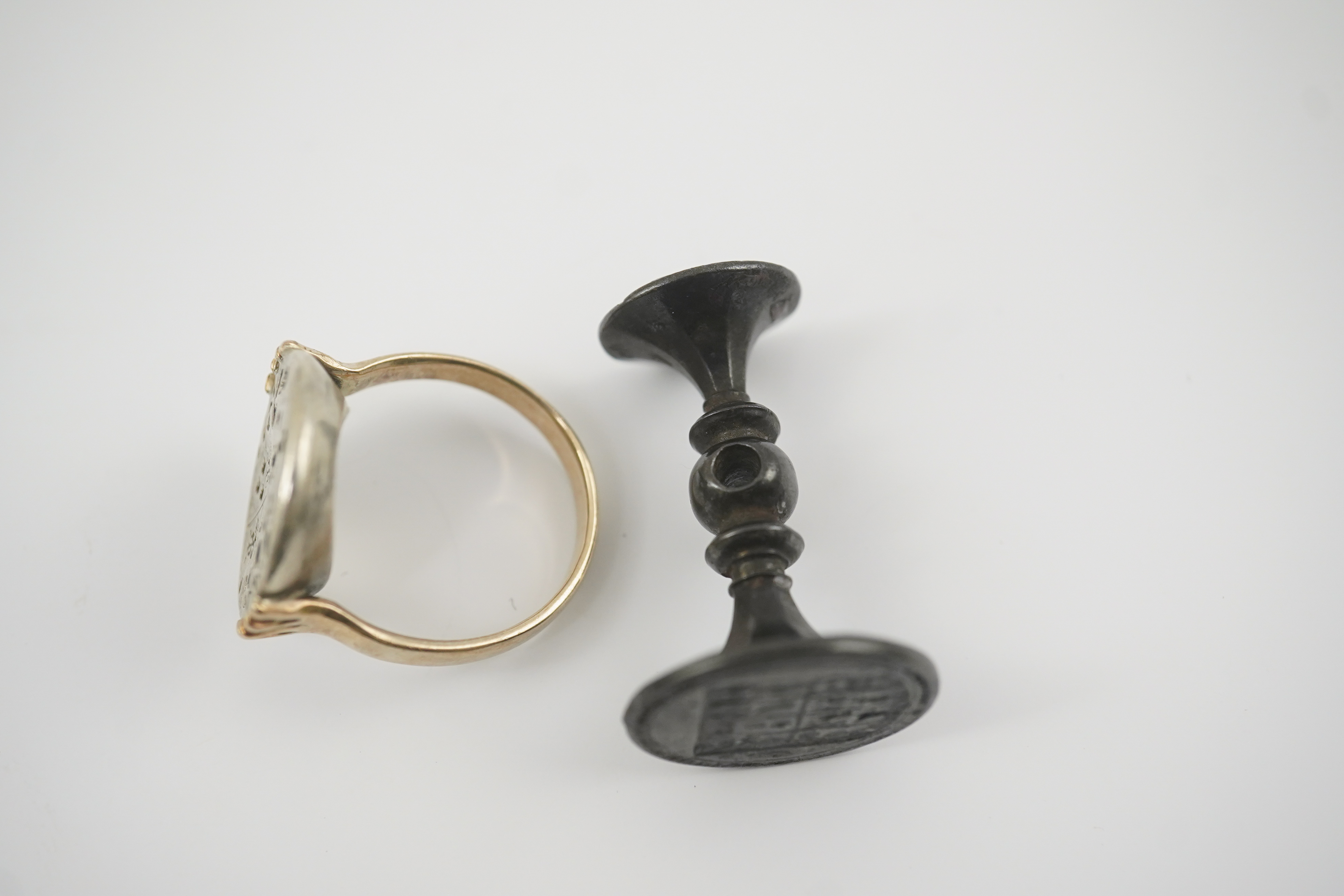 An early 18th century silver and gold signet ring, embossed with an armorial, size R, together with a steel double ended fob seal